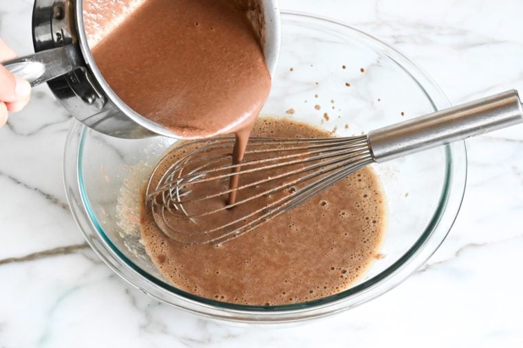 adding the chocolate mixture to the egg mixture