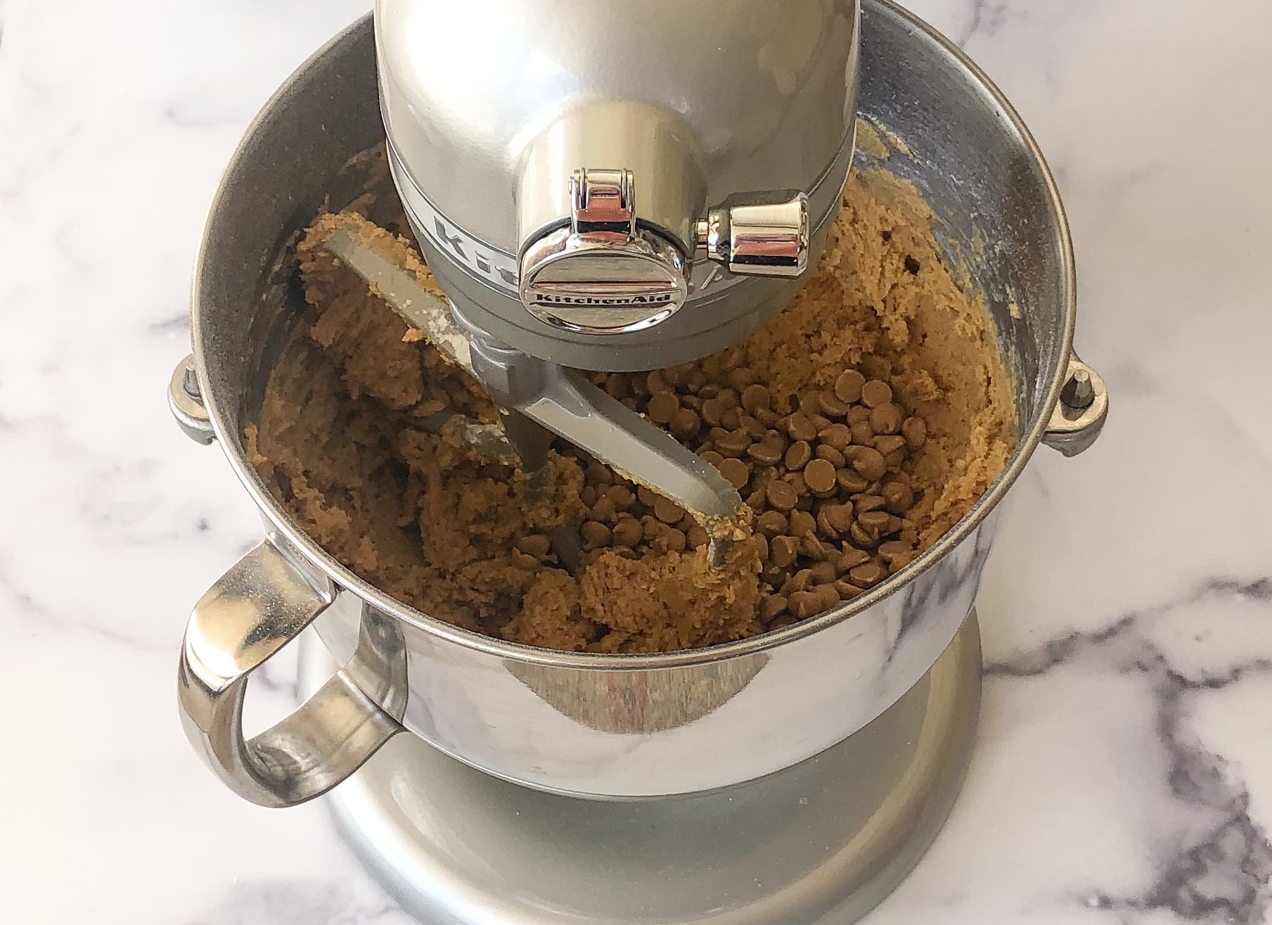 Adding the peanut butter chips and peanuts to the stand mixer.