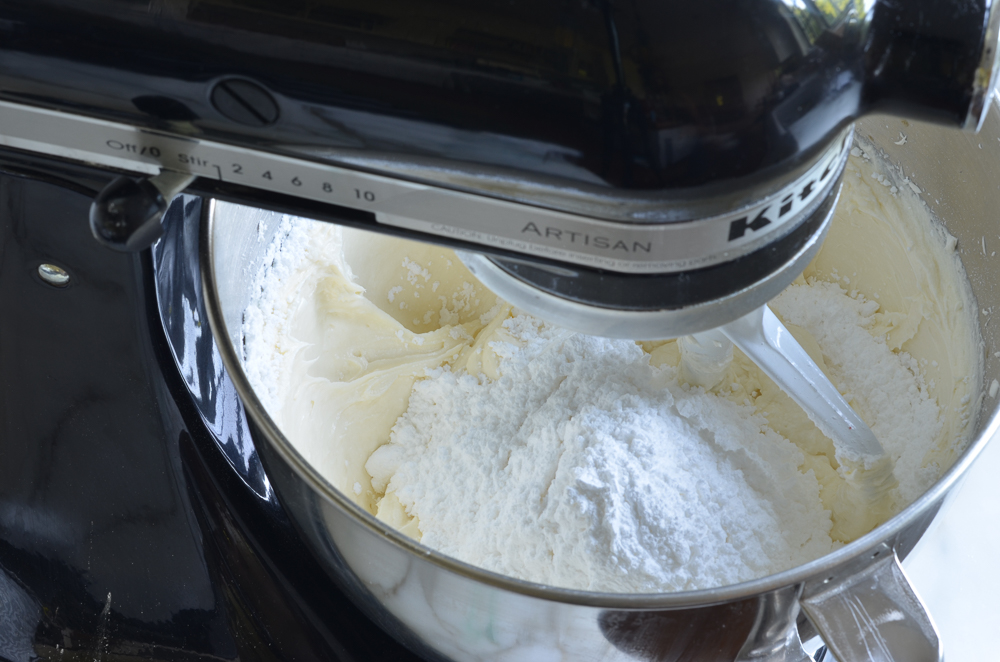 gradually adding the confectioners sugar to the frosting