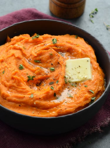 Pat of butter melting into a bowl of mashed sweet potatoes.