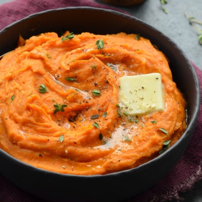 Pat of butter melting into a bowl of mashed sweet potatoes.