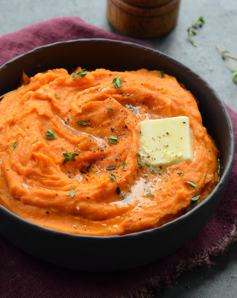 Pat of butter melting into a bowl of mashed sweet potatoes.