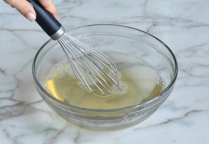 Whisk in a bowl with grape juice mixture.