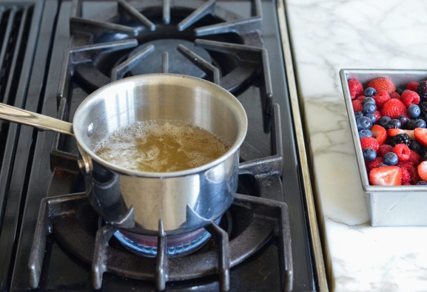 Juice and sugar boiling in a sauce pan.
