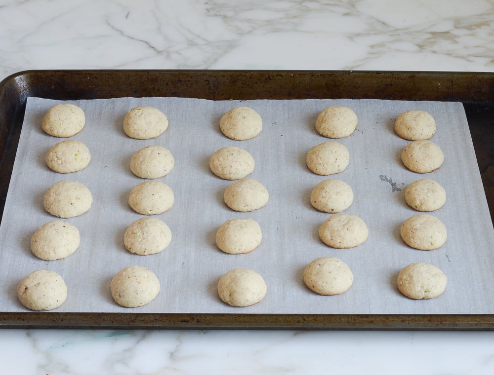 Lined baking sheet of baked cookies.