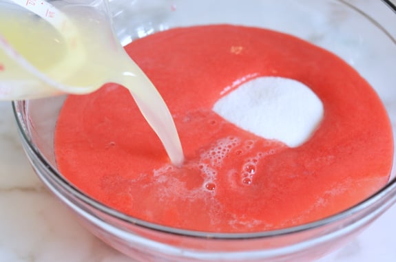 Lemon juice and sugar being added to raspberry puree.