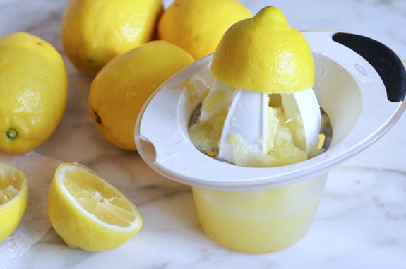 Halved lemon on a manual juicer.