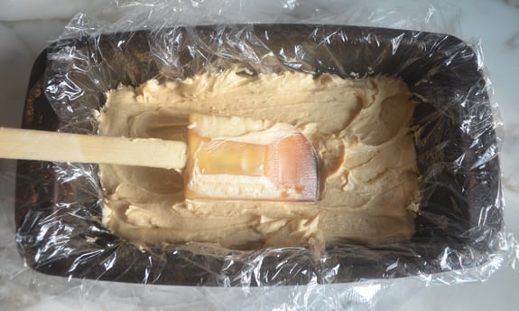 Peanut butter cream in a lined loaf pan.