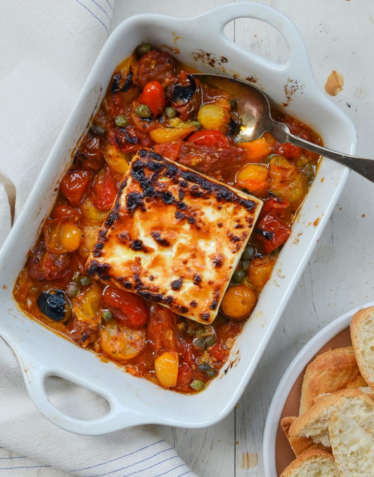 Baking dish of broiled feta with garlicky tomatoes and capers.