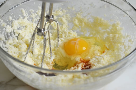 Eggs and vanilla in a bowl with butter and sugar.