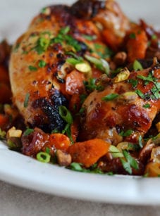 Plate of sweet and spicy roast chicken with carrots, dates, and pistachios.