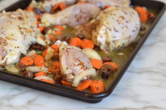 Marinaded chicken and vegetables on a baking sheet.