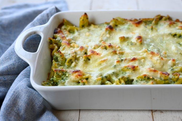 Penne with spinach, ricotta, and fontina in a baking dish.