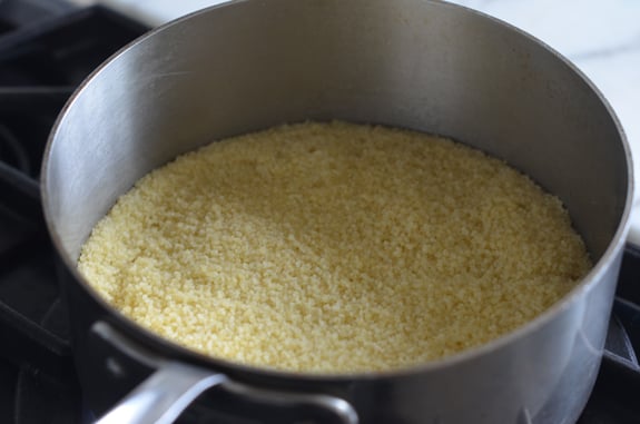 Steamed couscous in flat layer in a pot.