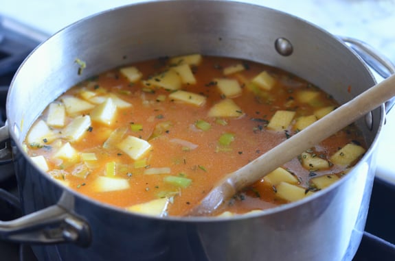 Wooden spoon in a pot of soup.
