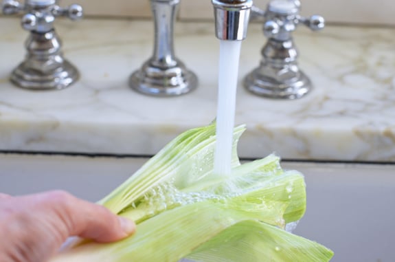 Person washing leeks under running water.