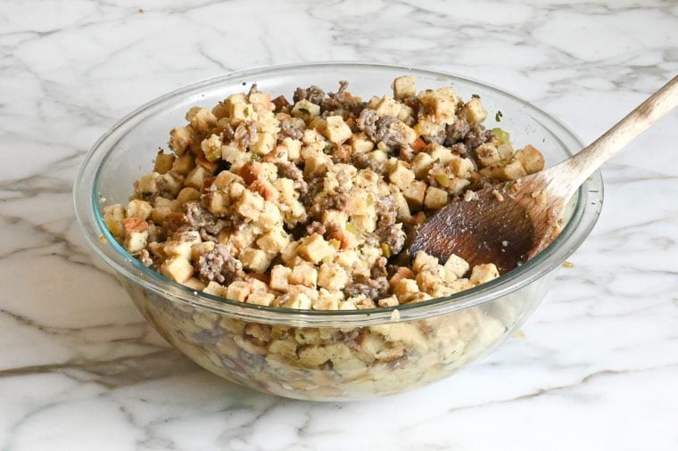 Wooden spoon in a bowl of stuffing mixture.