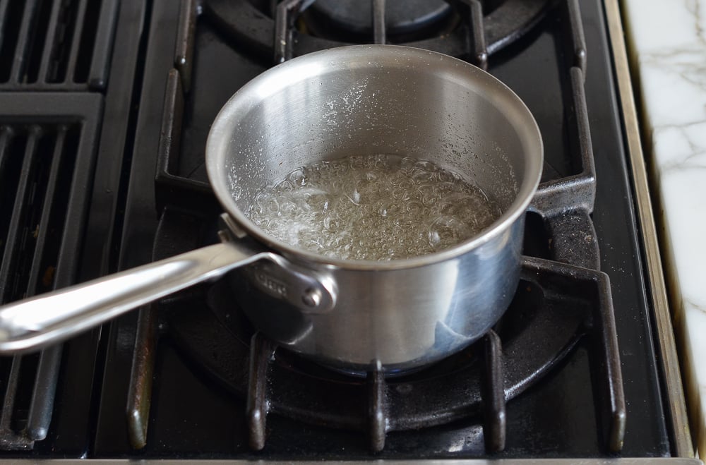 Bringing sugar and water mixture to a boil in a saucepan.
