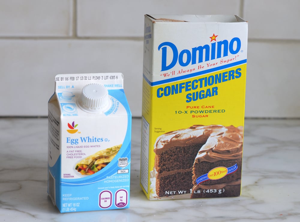 Containers of egg whites and confectioners sugar.