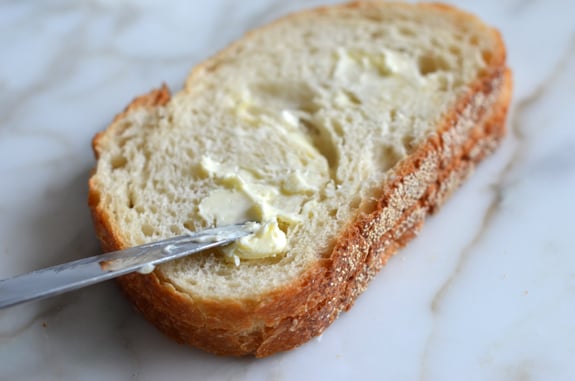 Knife buttering a piece of bread.