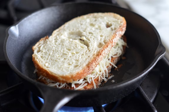Cheese and sun-dried tomato pesto sandwich in a skillet.