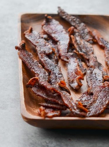 Wooden plate of candied bacon.