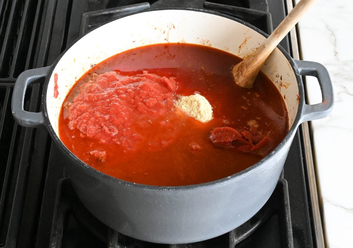 adding tomatoes, tomato paste, broth, and cornmeal