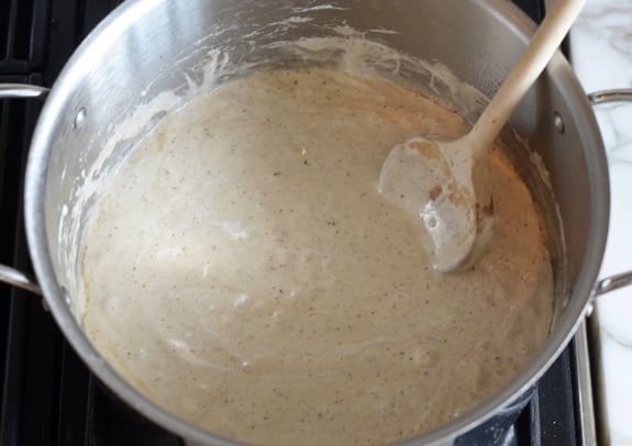 Wooden spoon in a bowl of melted marshmallow mixture.
