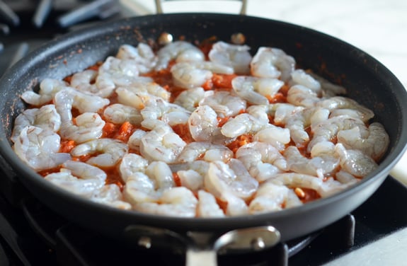 Shrimp in a skillet with tomato sauce.
