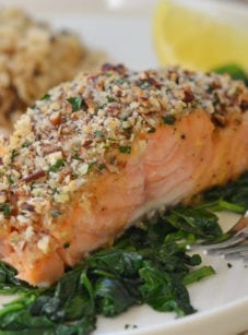 Baked salmon with honey mustard and pecan-panko crust on a plate with a fork.