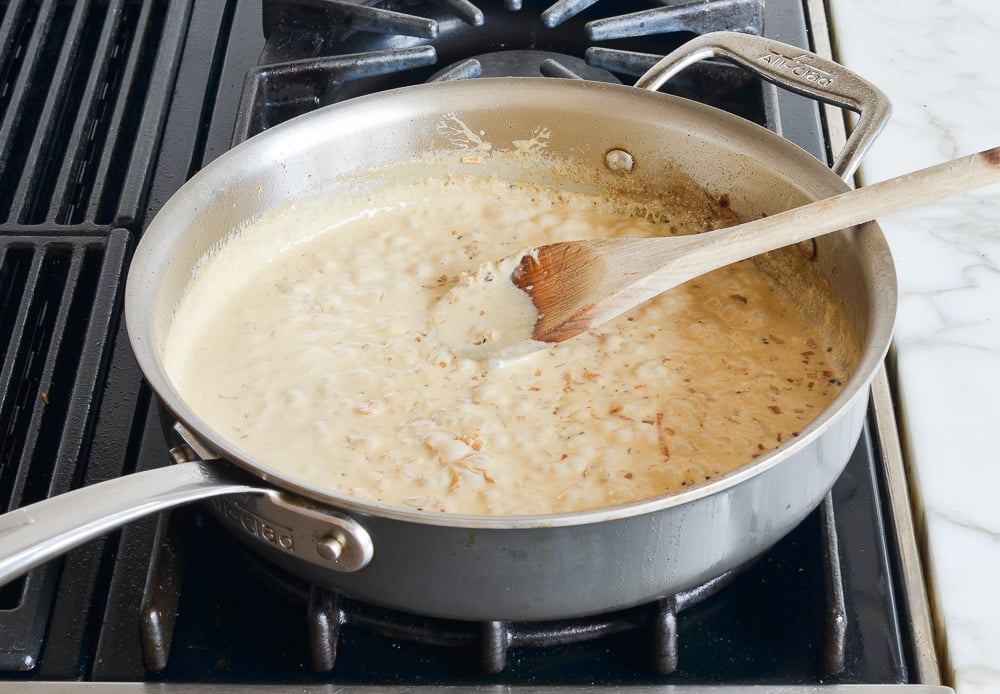 Skillet of thickened Cognac peppercorn sauce.