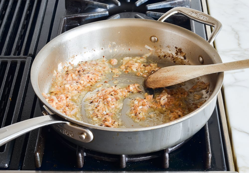 Softened shallots in a skillet.