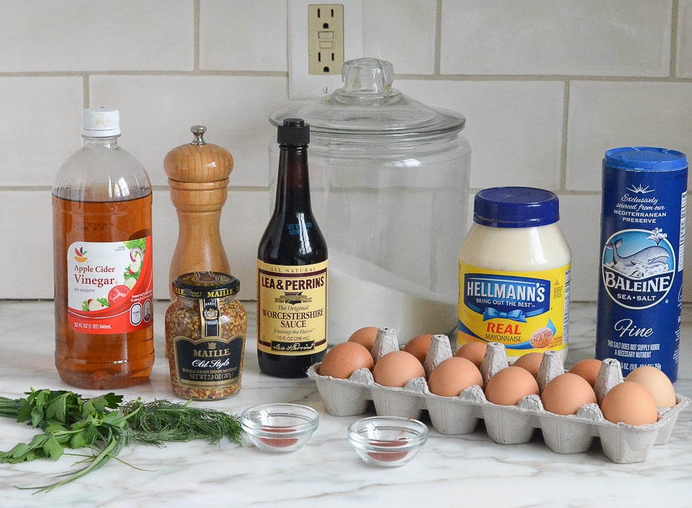 Deviled egg ingredients including Worcestershire sauce, mayonnaise, and apple cider vinegar on the counter before mixing. 