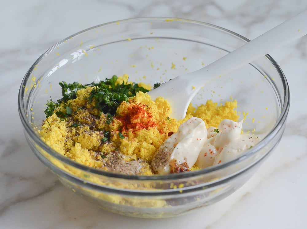 Mayonnaise, egg yolk, and other ingredients in a bowl for the deviled egg filling.