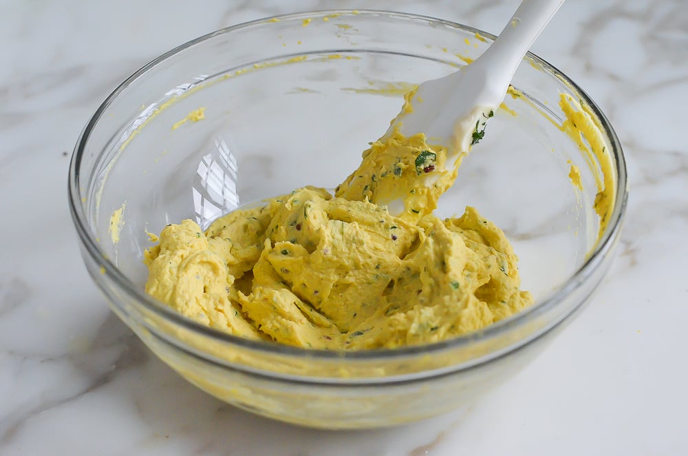 Spatula in a bowl of smooth deviled egg mixture.