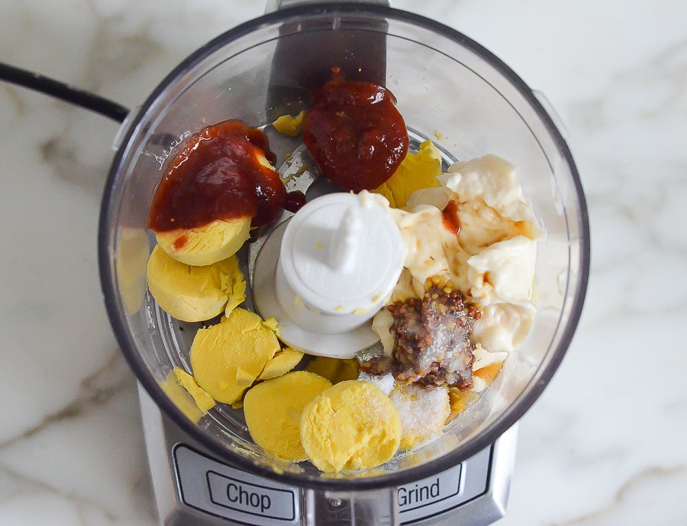 Hard-boiled egg yolks in a food processor with mayonnaise and flavorings.