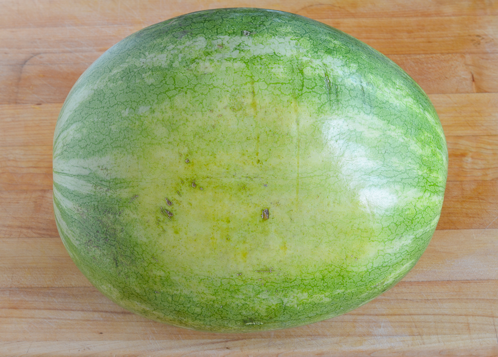 Whole watermelon on a cutting board.