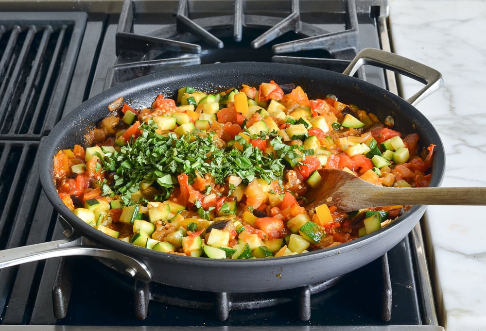 Basil in a skillet with ratatouille.