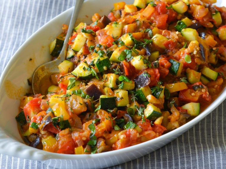 Spoon in a dish of Ratatouille.