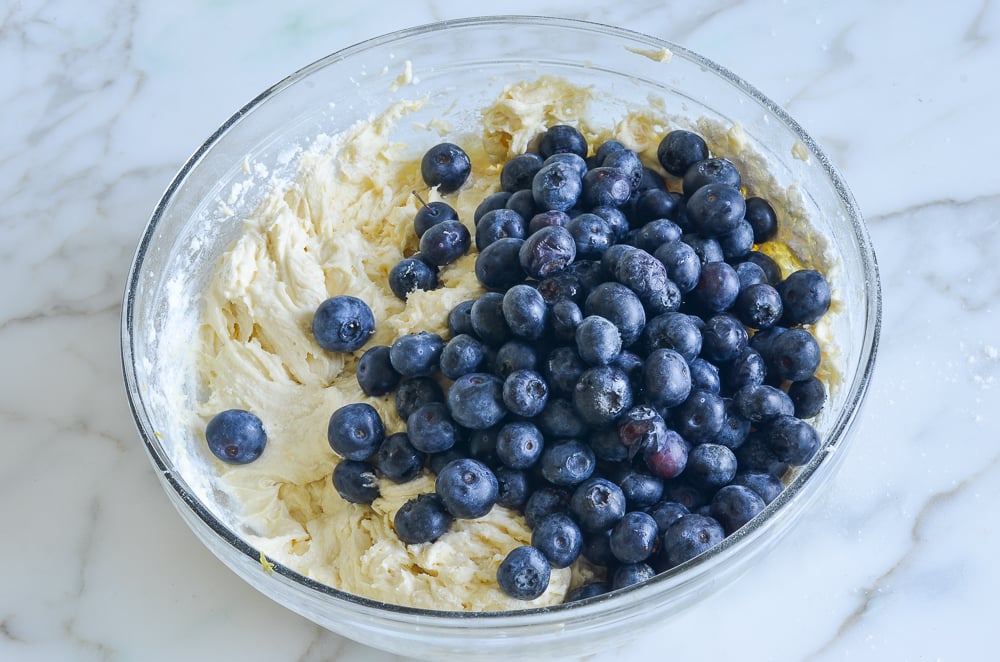Blueberries in a bowl with coffee cake batter.
