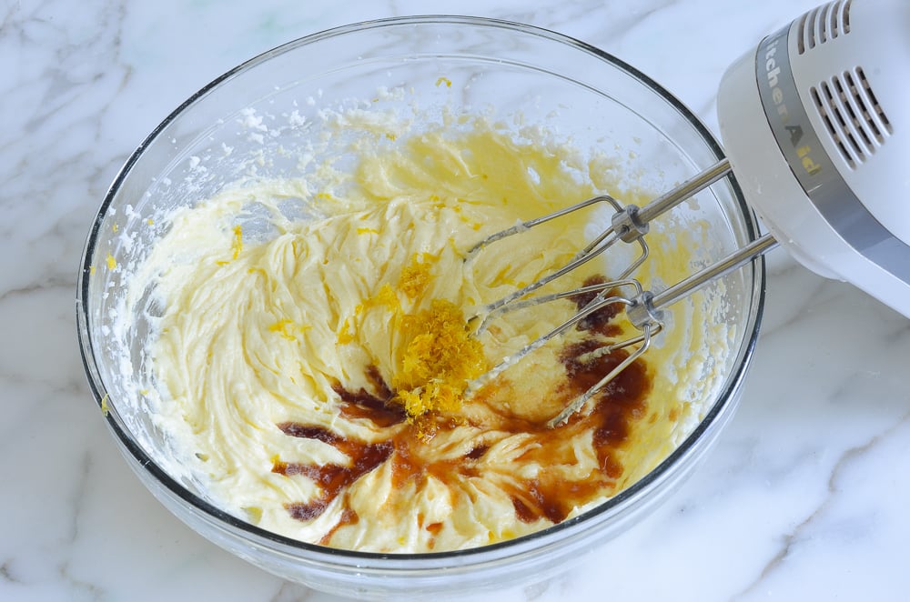 Vanilla extract and lemon zest in a bowl with an egg mixture.