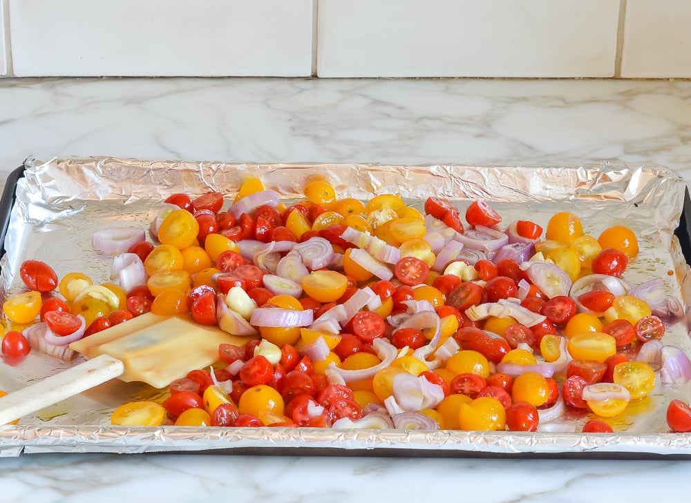 tossing tomatoes, shallots, and garlic with oil and seasoning