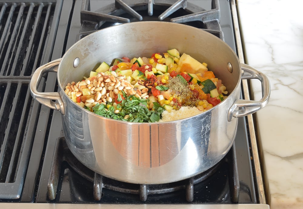 mixing the pasta with the other ingredients in pot