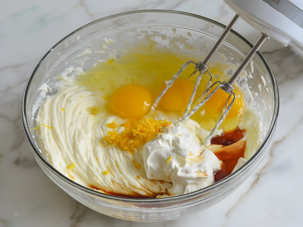 Eggs and other ingredients in a bowl with a cream cheese mixture.
