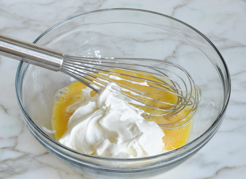 Sour cream and cream cheese in a bowl with eggs.