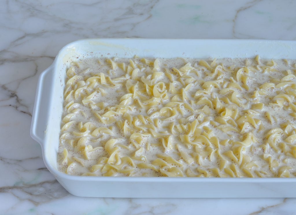 Noodles and custard mix in a baking dish.