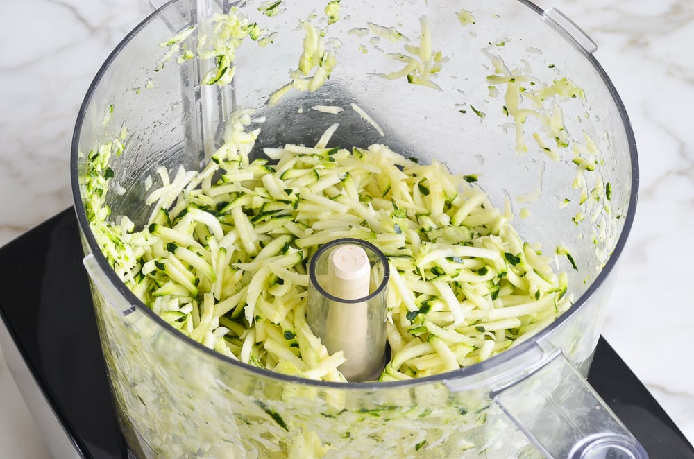 Shredded zucchini in a food processor.