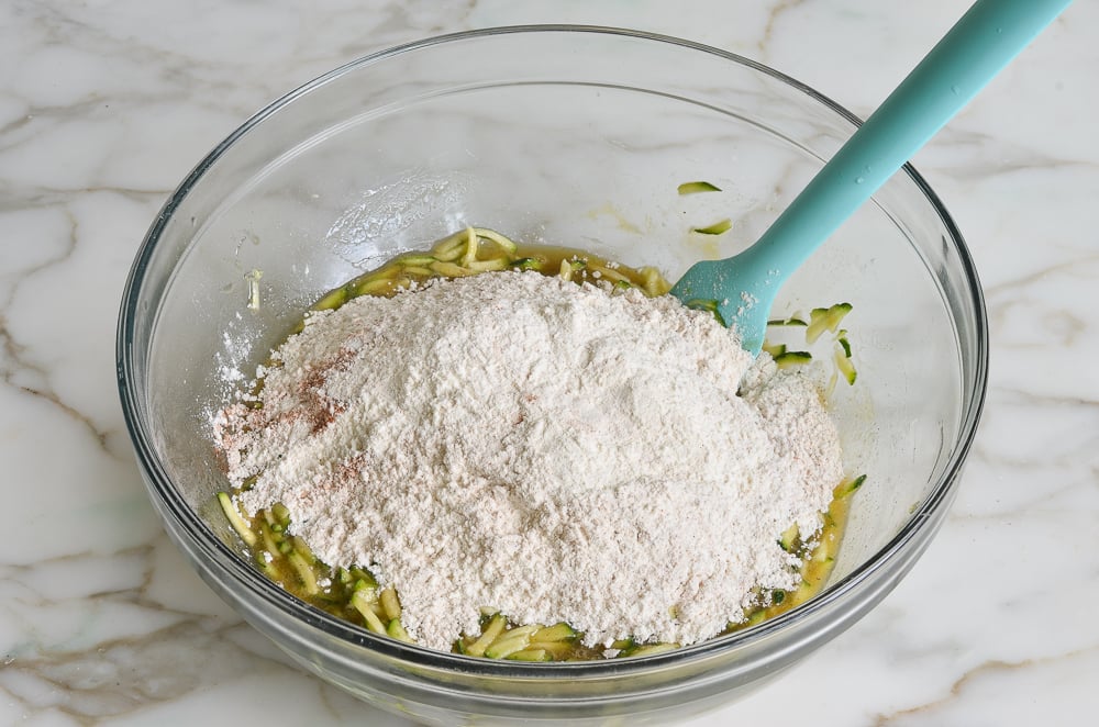 Dry ingredients being added to the zucchini muffin batter.