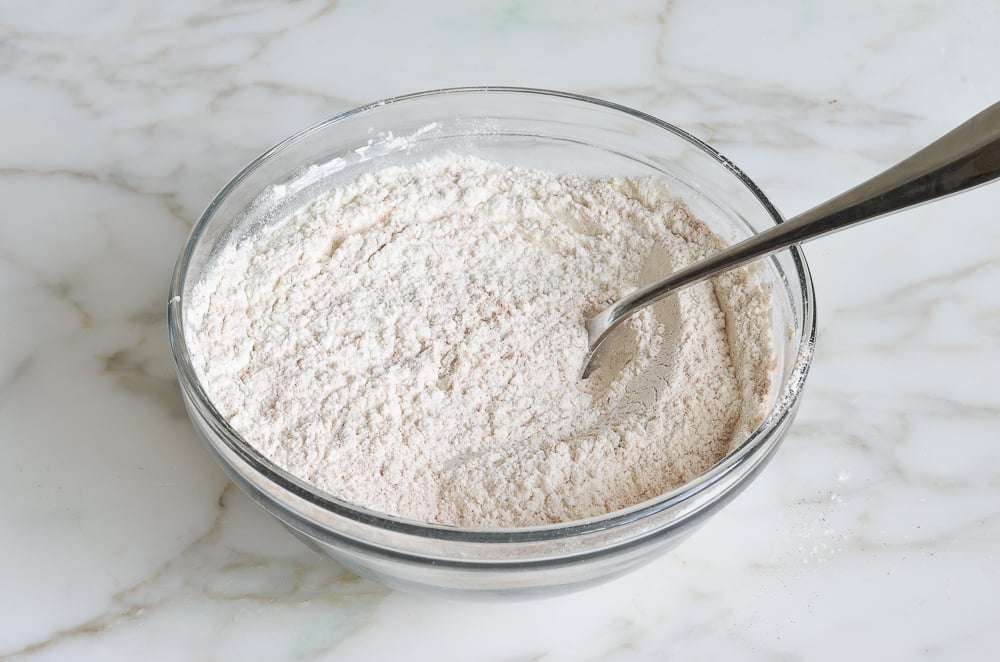 Dry ingredients mixed in a glass bowl.