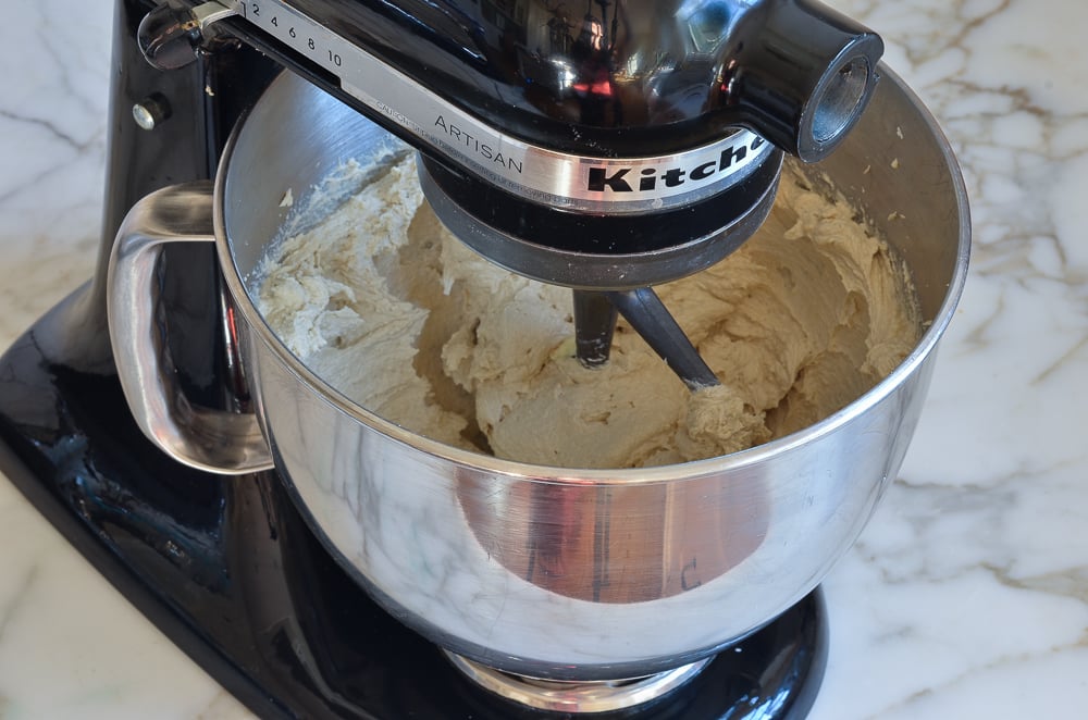 Eggs added to a stand mixer with a butter and sugar mixture.